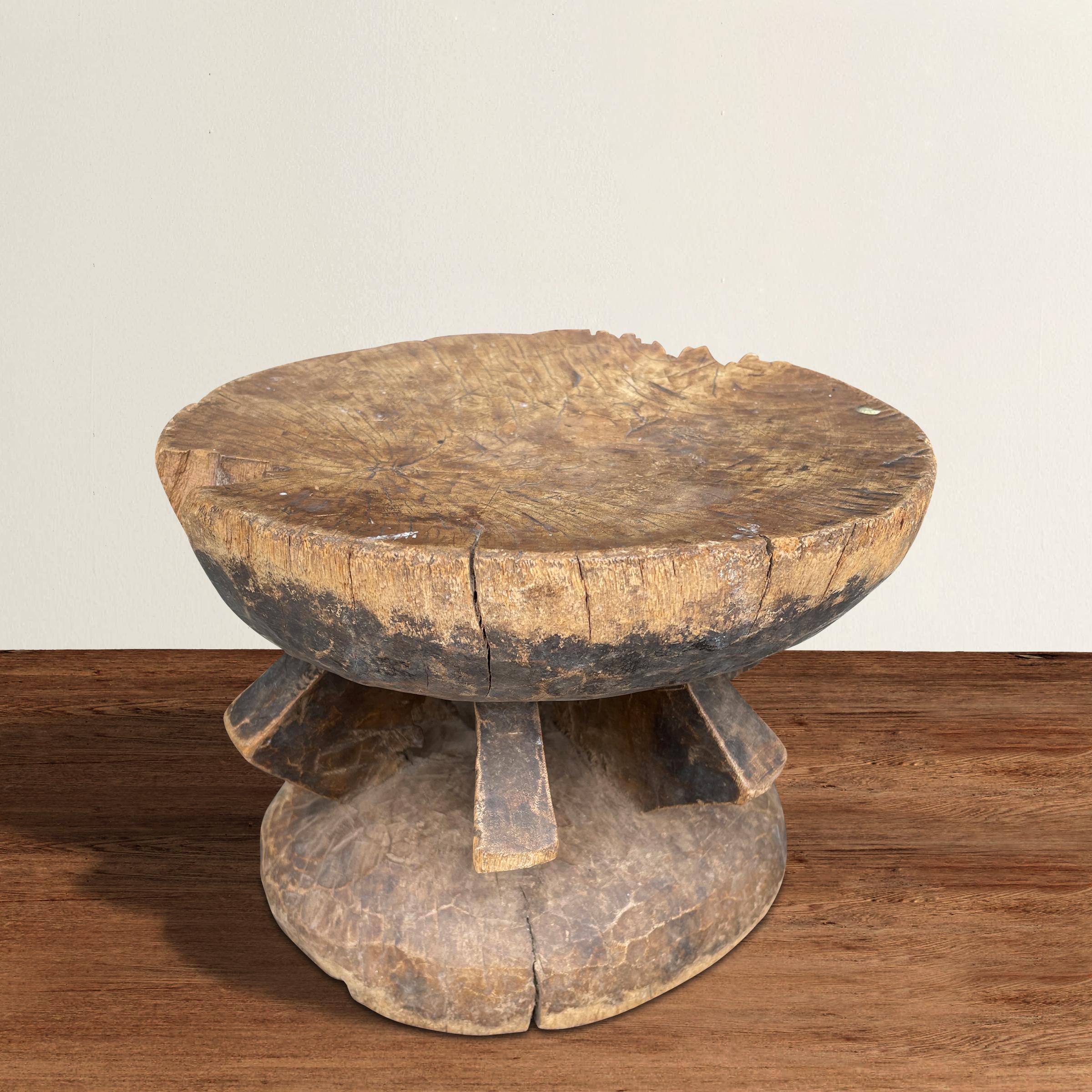 A fantastic and bold Dogon stool carved from one piece of wood, and with several geometric 'legs' supporting a half-round seat and base, and with a wonderful patina only time can bestow. Perfect as a small perch next to your favorite armchair, or as