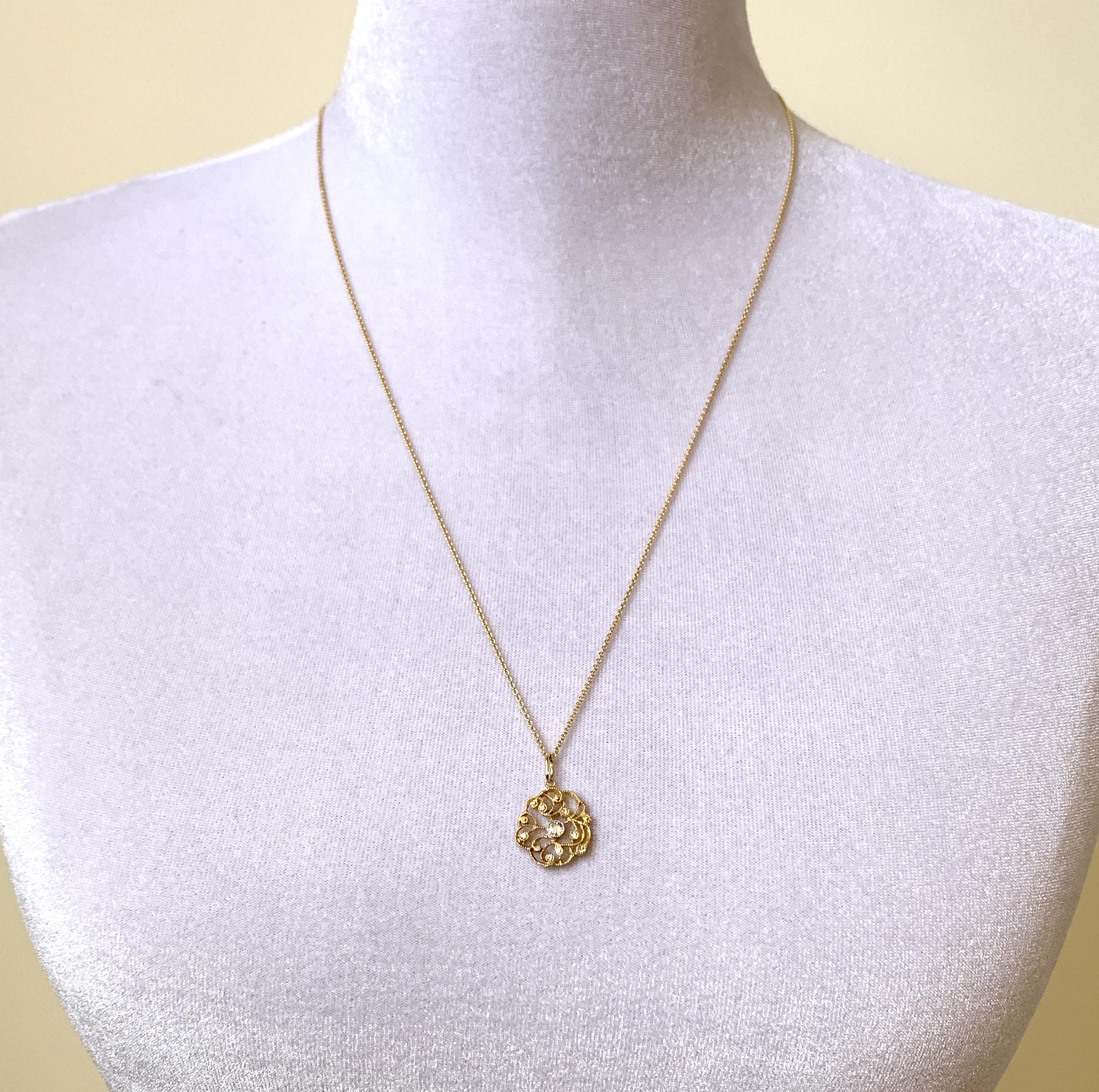 This original design by Eytan Brandes is one of his evergreens.  He's used this lacy floral (but not precious or fussy) rondelle as a pendant, as a chain link, and as earrings.  

This latest version is in rich, vivid 18 karat yellow gold,
