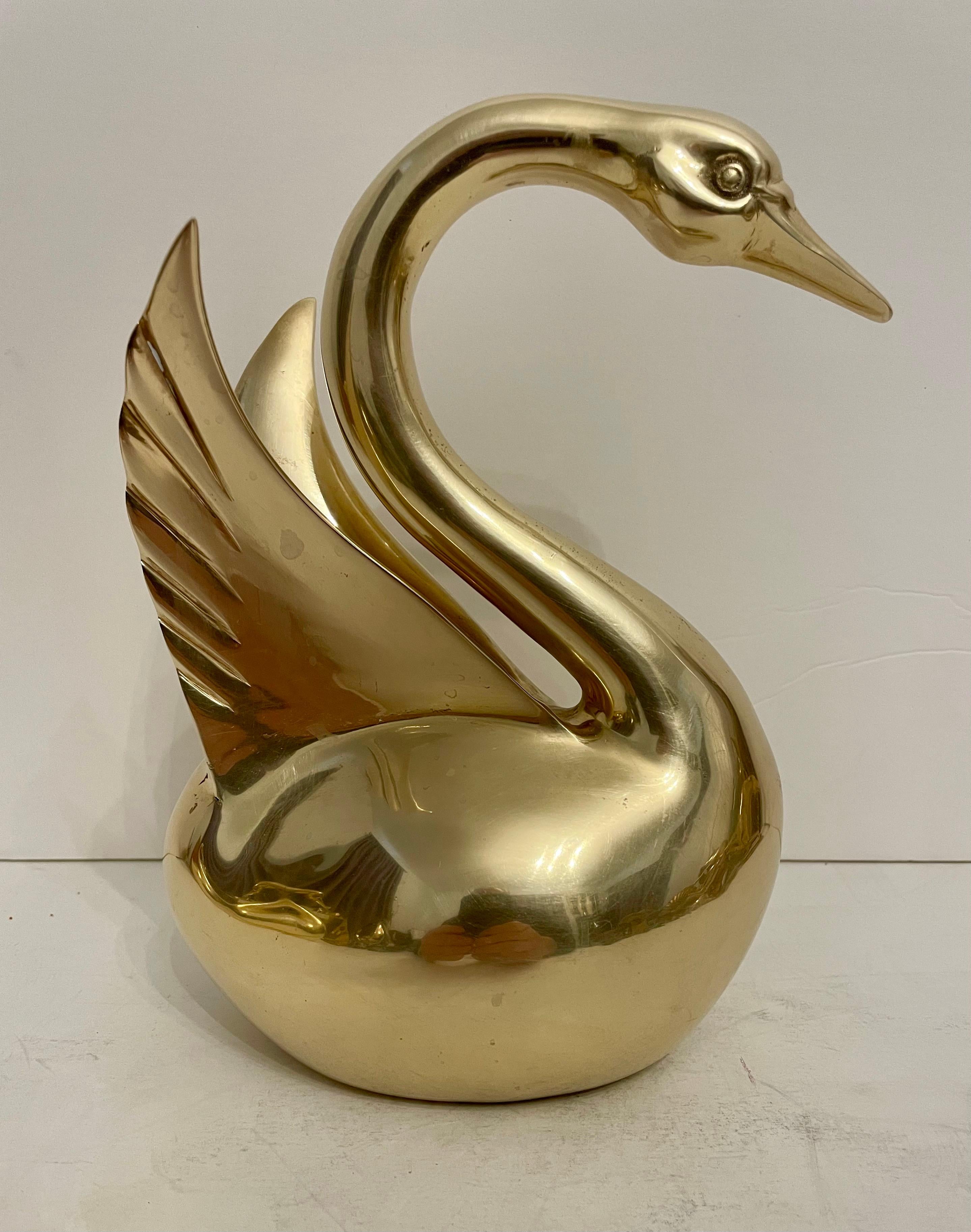 Dolbi Cashier Large Brass Swan Sculpture with feathers spread.  Heavy for size. Superior Quality.  Looks great on a bookshelf or table. Good hand polished condition, light and dark areas are glare from light.