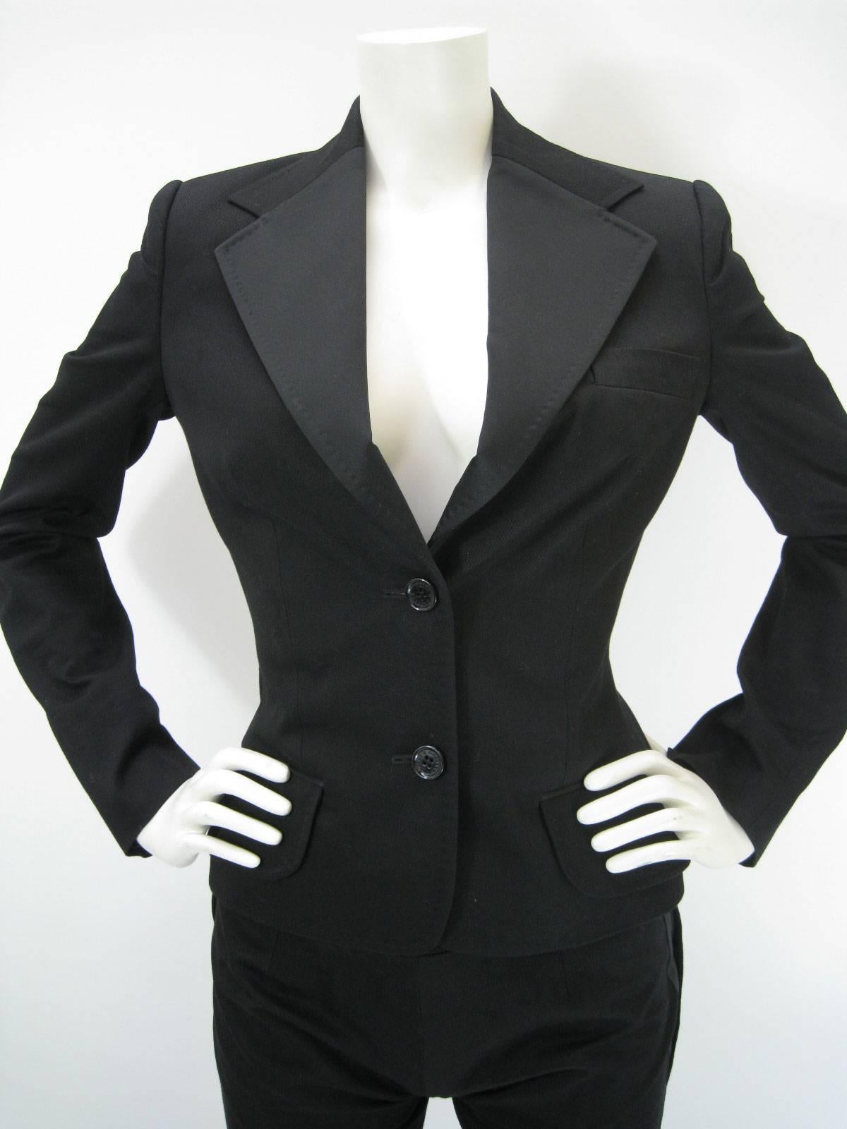 Dolce & Gabbana black satin trim pantsuit.

Tuxedo style jacket and slacks.

Jacket is fitted and has satin lapel.

Two button closure, chest pocket & faux front pockets.

Pants feature wrap around cummerbund with buckle, sailor style buttons and