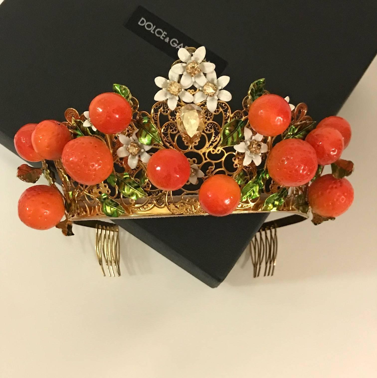 Dolce & Gabbana orange embellished tiara from the Resort 2016 collection. A super iconic Dolce & Gabbana piece!

Gold plated brass lattice base covered in Swarovski crystals, resin leaves & enamel oranges.

Combs at each side hold in crown in place.