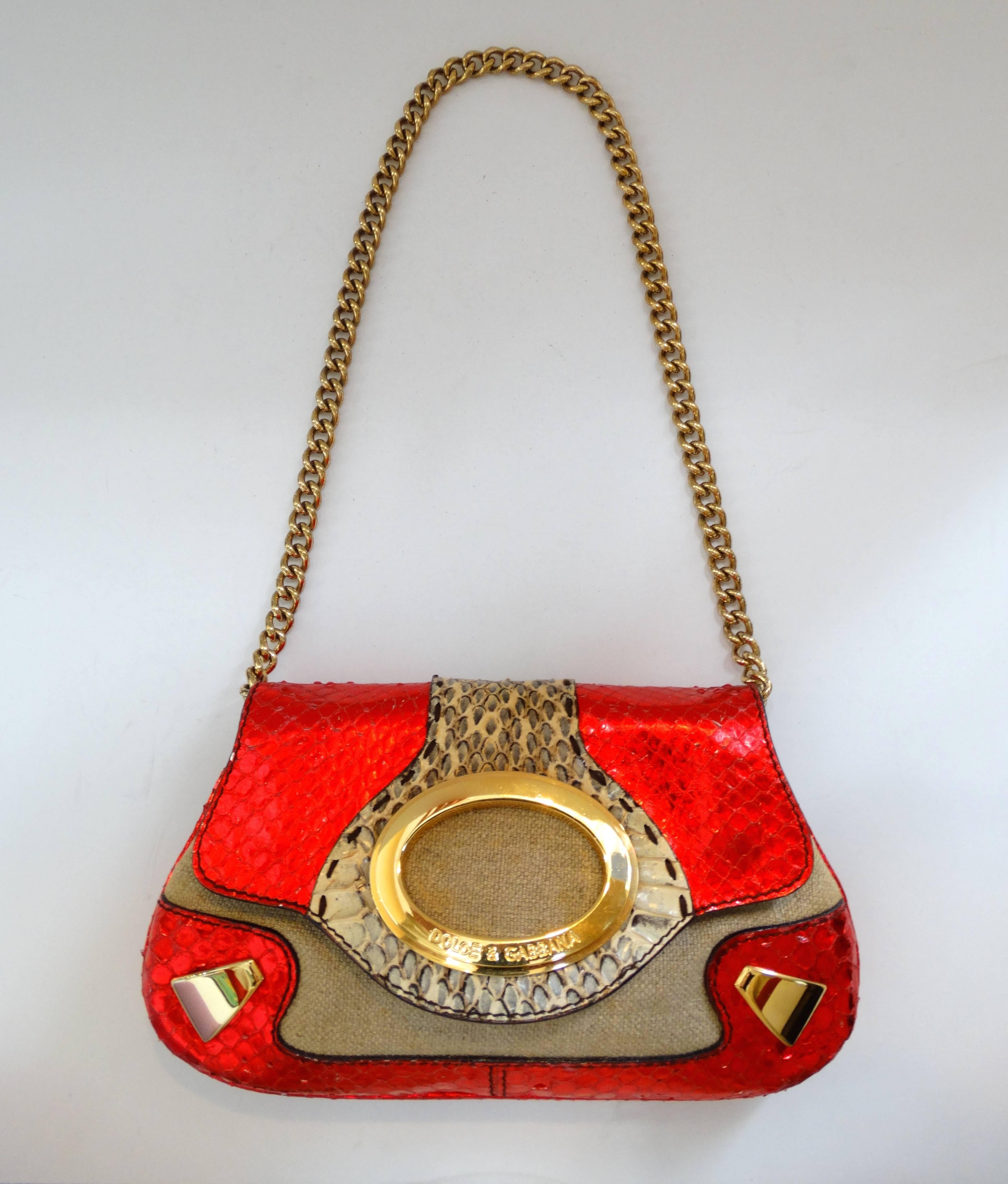 Your new favorite going out bag has landed! This amazing Dolce & Gabbana bag is made of a metallic lipstick red snakeskin embossed leather, contrasted with tan snakeskin down the middle. Burlap like canvas material beneath the flap, accented by gold