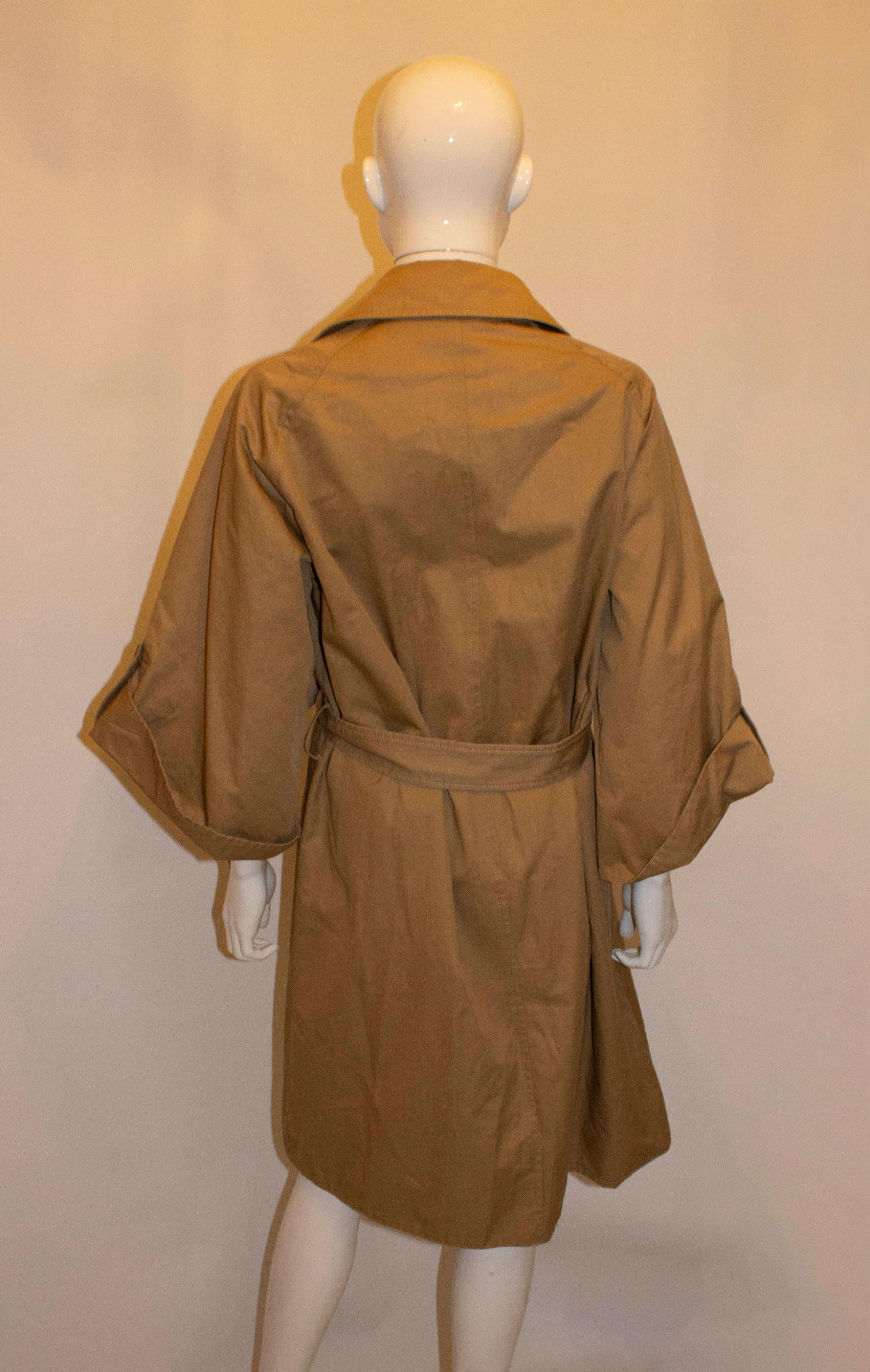 A great raincoat / jacket by Dolce and Gabanna . The coat is in a caramel colour with wonderful sleaves  , self fabric belt and stripe lining.  Size 40 Measurements: Bust up to 39'',length 40''