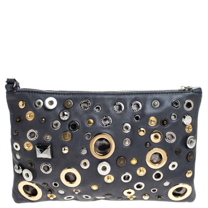 Presenting an edgy and glamorous clutch to go with your evening looks! From Dolce&Gabbana, this clutch is crafted in ash blue leather and is embellished with studs and eyelets all over. A zipper opens to a fabric-lined interior and the clutch is