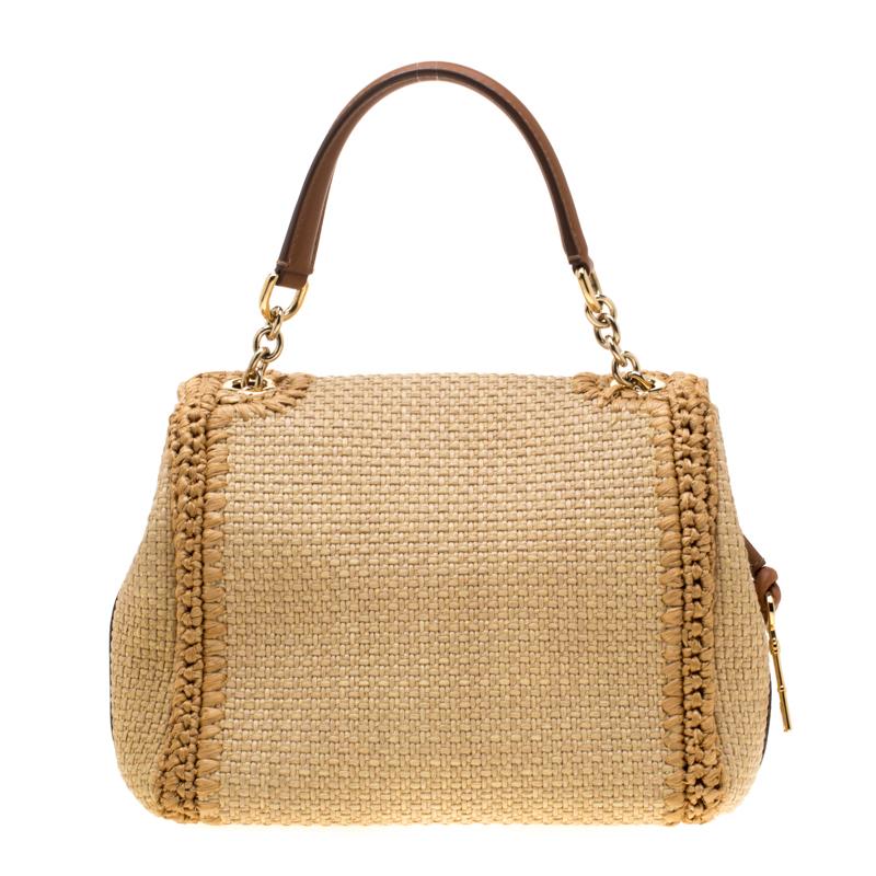 Perfect to make heads turn and flaunt all day long, this Dolce and Gabbana Miss Dolce tote looks stunning! The beige creation is crafted from a combination of raffia and leather into a beautiful shape featuring a woven design. It has a front flap