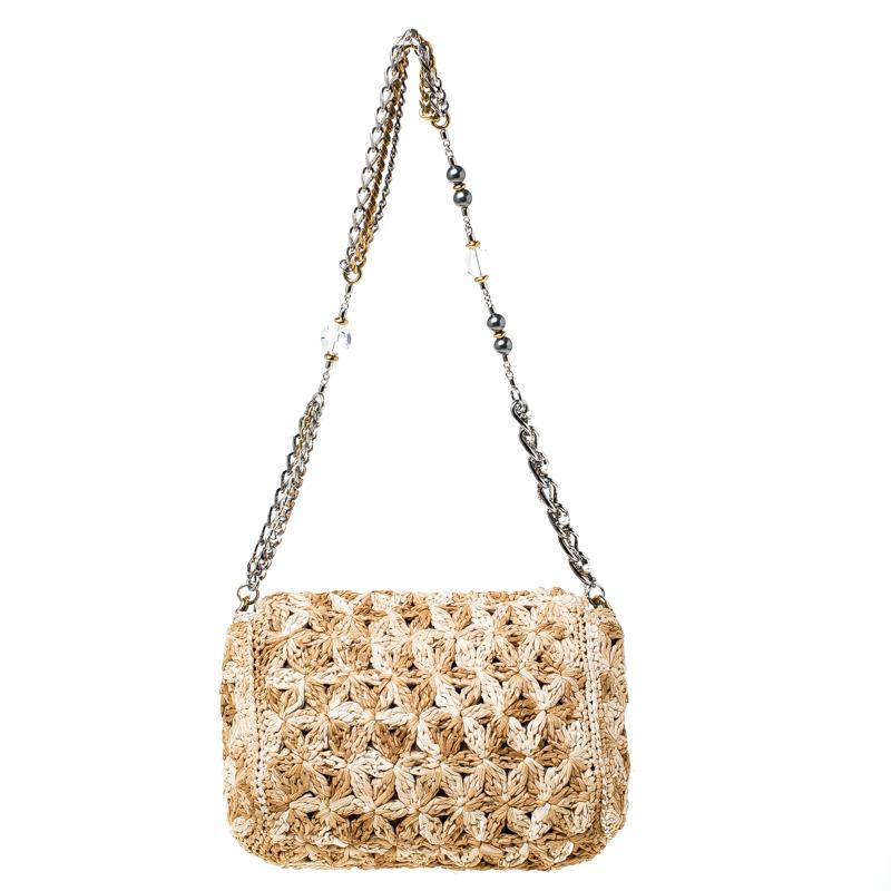 This Miss Charles bag by Dolce & Gabbana is both unique and chic. Crafted from woven raffia, it features an intriguing design over the exterior, a hardware plaque carrying the brand name and chain-link shoulder straps embellished with crystal and