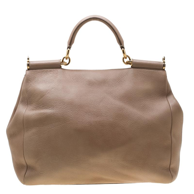 This gorgeous beige tote from Dolce & Gabbana is a leather bag coveted by women around the world. It has a well-structured design and a front flap that opens to a fabric lined compartment with enough space to fit your essentials. This creation