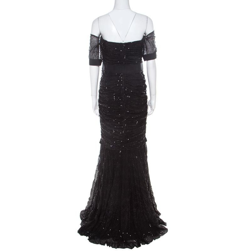 Beautifully adorned with shimmery sequins, this Dolce and Gabbana off-shoulder gown is ideal for special events. The floor-grazing length and classic black color combine to make it as sophisticated as elegant it is. It is complete with ruched design