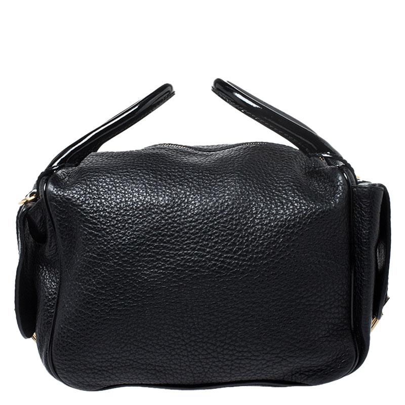 This stunning shoulder bag by Dolce & Gabbana makes a statement. Crafted in Italy, it is made of patent leather and leather and comes in a classic shade of black. It has a lovely silhouette, features dual handles, a detachable shoulder strap,
