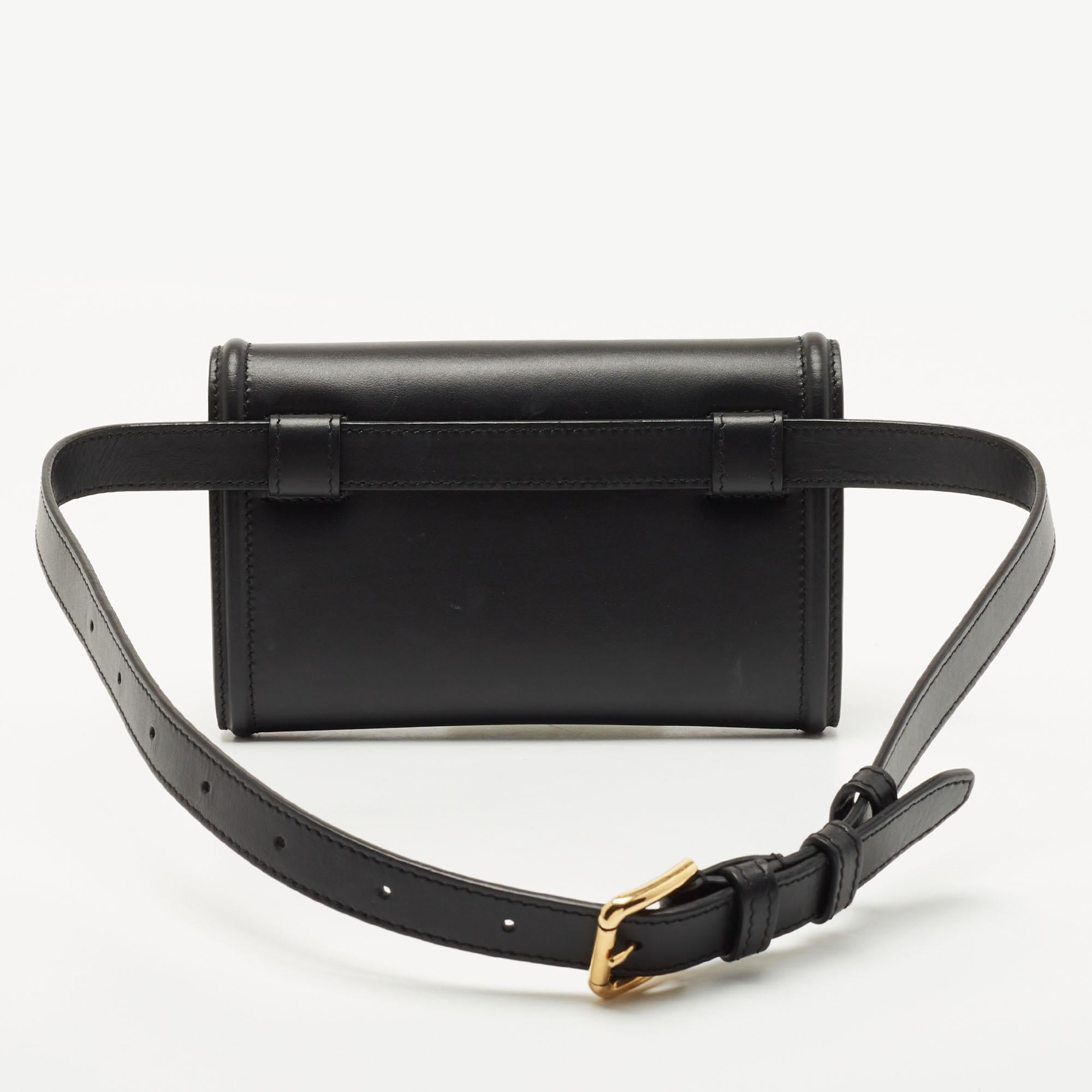 Be a part of the latest trends with this amazing belt bag from Dolce & Gabbana. Crafted with leather, the black bag comes with a front flap featuring the gold-tone Devotion heart motif. Equipped with a roomy leather-lined interior and an adjustable
