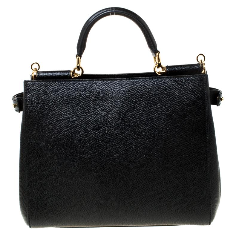 The ‘Miss Sicily’ bag from Dolce & Gabbana is iconic and timeless. This black leather creation is structured with two compartments and secured by snap fasteners. It has a convenient chic top handle and an adjustable leather shoulder strap. The