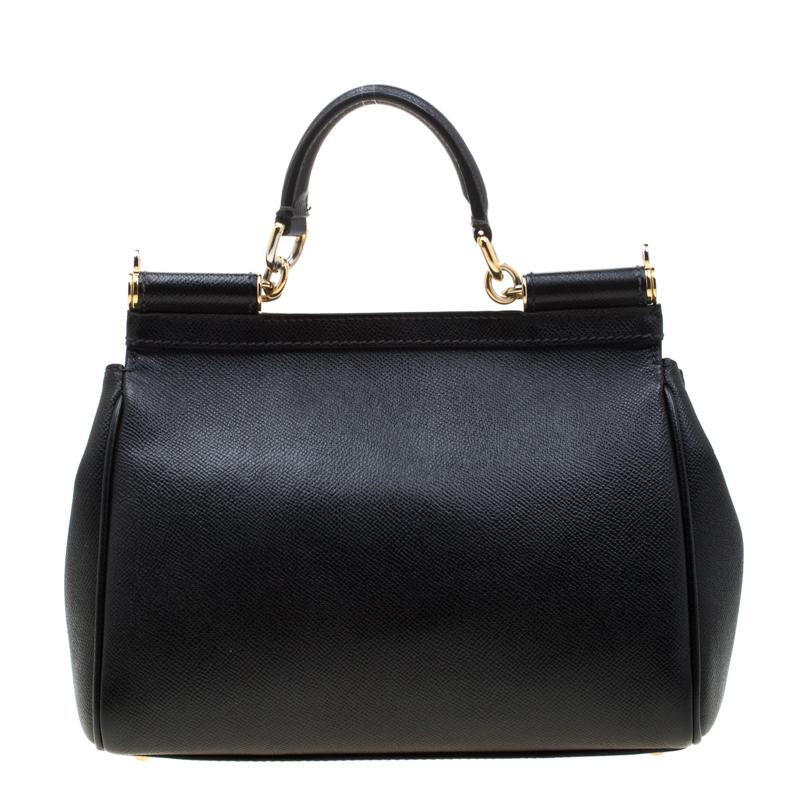 This gorgeous black Miss Sicily tote from Dolce & Gabbana is a handbag coveted by women around the world. It has a well-structured design and a flap that opens to a compartment with fabric lining and enough space to fit your essentials. The bag