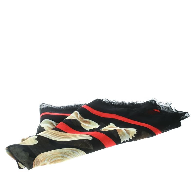 Add this lovely Dolce and Gabbana scarf to your collection and stand out in the crowd! This black creation is made of 100% silk and features a quirky pasta print all over it. It is styled with gauze fringed edges that add to its appeal. It is sure