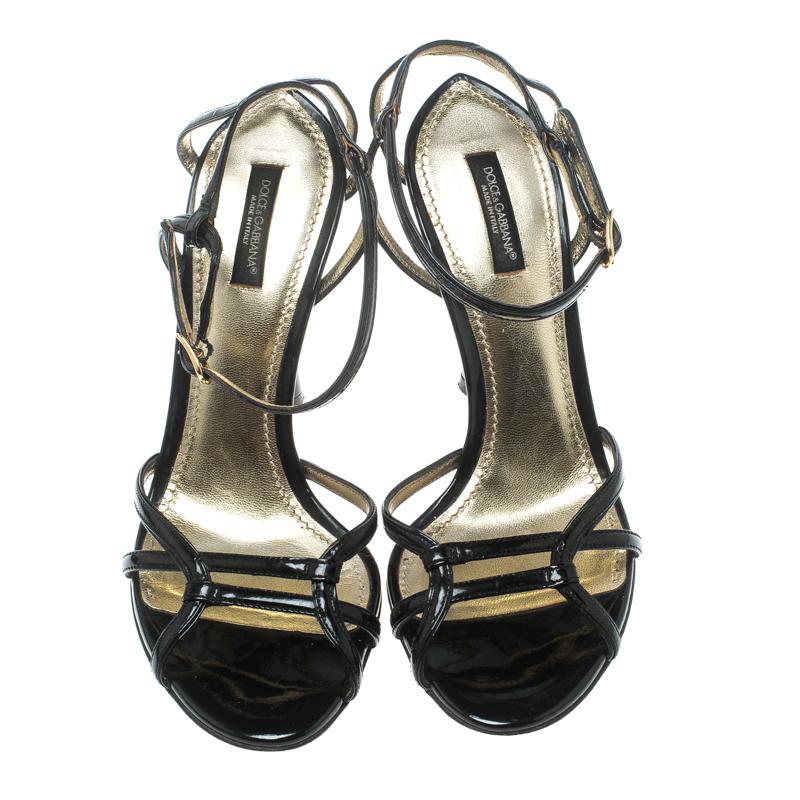 Given the right pair of sandals, you are sure to shine all day long! These black Dolce and Gabbana sandals are crafted from patent leather and feature an open toe silhouette. They flaunt conjoined vamp straps, buckled ankle fastenings, comfortable