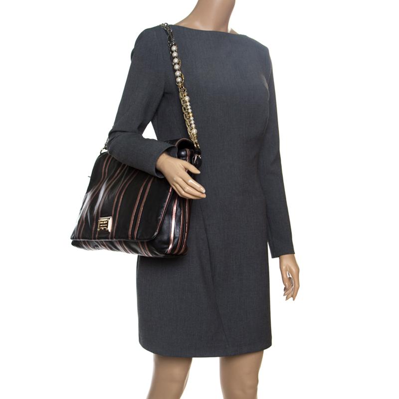 This shoulder bag by Dolce and Gabbana is a lovely handbag to own. The exterior is made from black leather with pink stripes. It is finished with a front Dolce and Gabbana plaque and showcases a chain link strap that is ornamented with pearls and