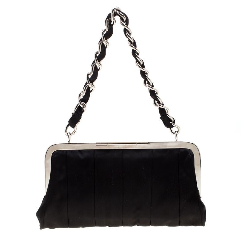 With an interwoven chain handle, the black satin clutch from Dolce & Gabbana exudes luxury! The precise design is defined by a structured frame in silver-tone metal. The beauty has a satin-lined interior with a patch pocket to hold your lipsticks