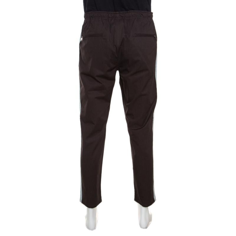 Now lounge around in comfort in these pants from Dolce and Gabbana. The brown pants are made of 100% cotton and feature a simple structured design. They flaunt stripe detailing on the sides and come with a tie-up fastening at the front, an