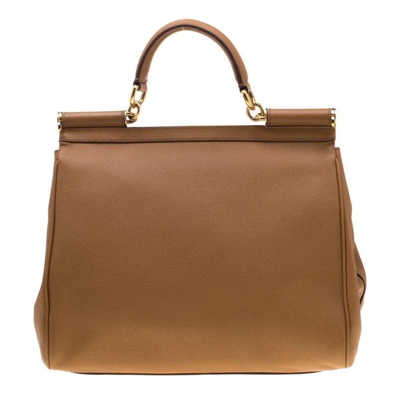 This gorgeous Brown Miss Sicily satchel from Dolce & Gabbana is a handbag coveted by women around the world. It has a well-structured design and a flap that opens to a compartment with fabric lining and enough space to fit your essentials. The bag