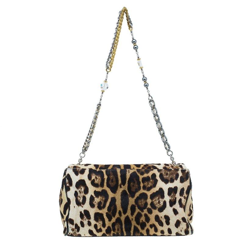 Dolce and Gabbana combines all the decorative elements into one functional bag. Crafted from exotic leopard print pony hair with leather trim, it features a chain strap with embellishments on it and a flap closure with a gold-tone logo plaque. The