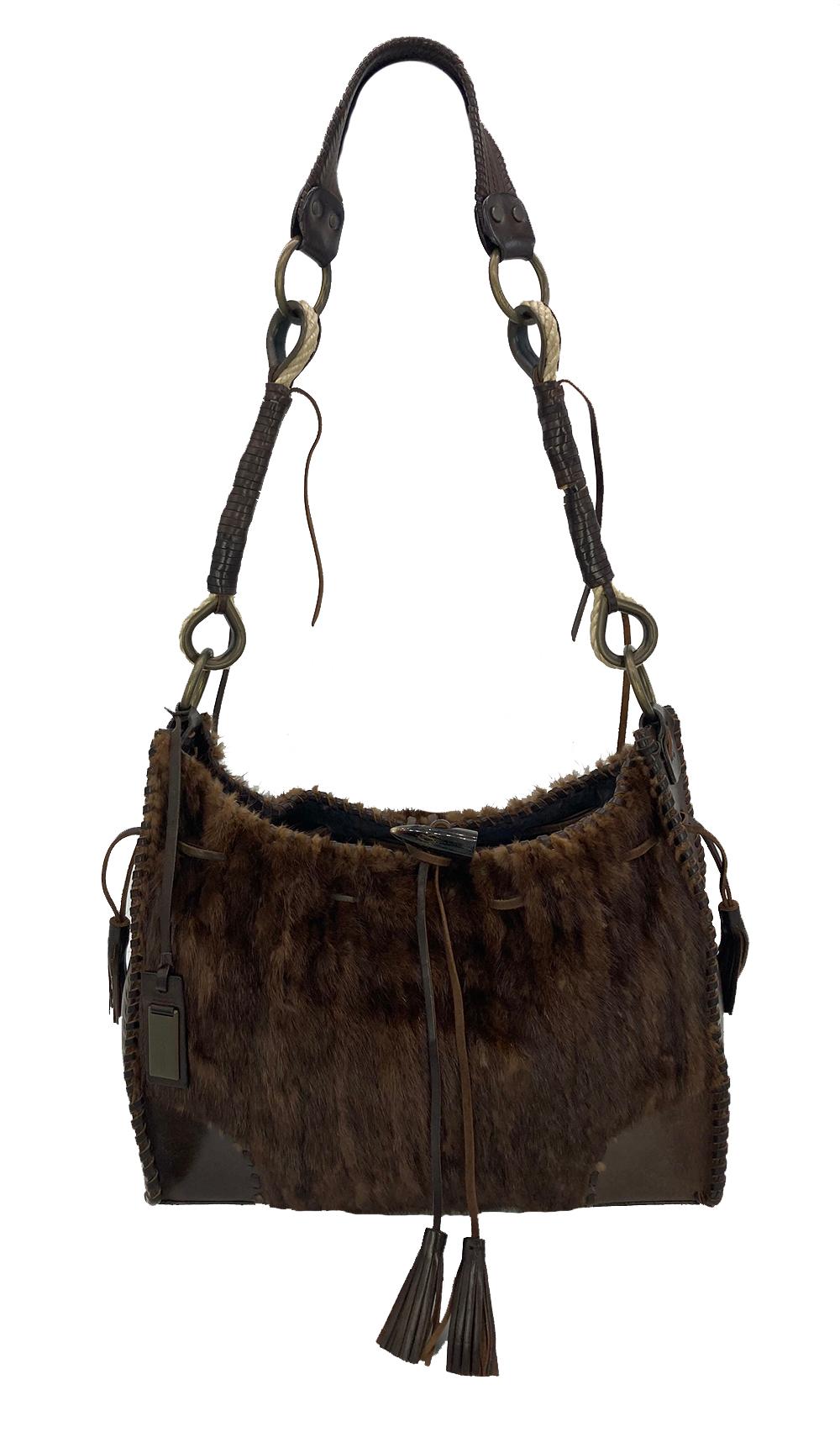 This exotic Dolce & Gabbana shoulder bag is in excellent condition. The exterior features gorgeous brown leather trimmed with matching brown mink fur with antiqued bronze hardware and woven leather detailing. Top resin bone leather loop closure