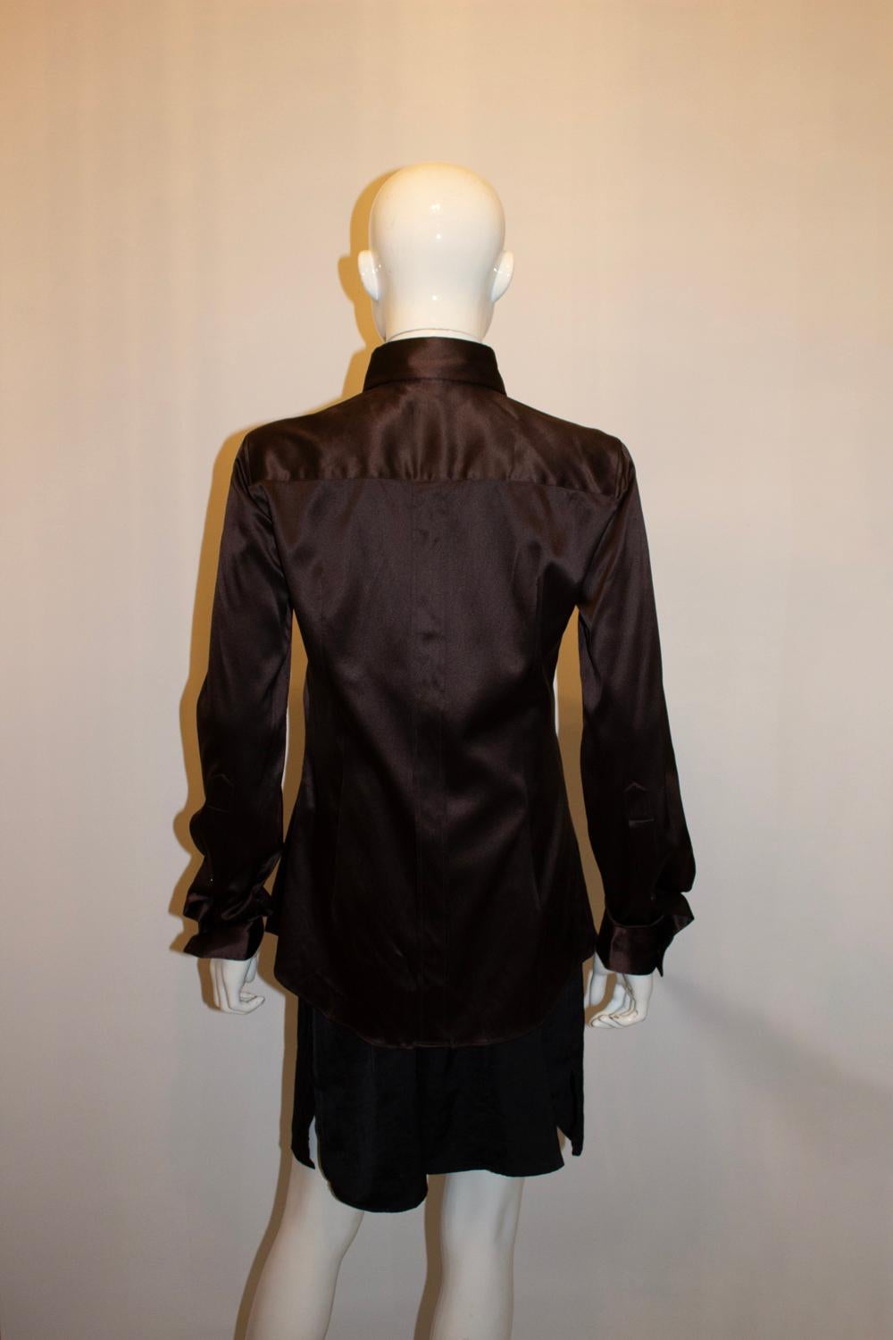 Una splendida camicia di seta di Dolce & Gabbana.  La camicia è in un tessuto morbidissimo con dettagli interessanti. 
Ha un doppio bottone sul colletto e un polsino a un bottone con un interessante dettaglio sulla manica. Ha un dettaglio di piega