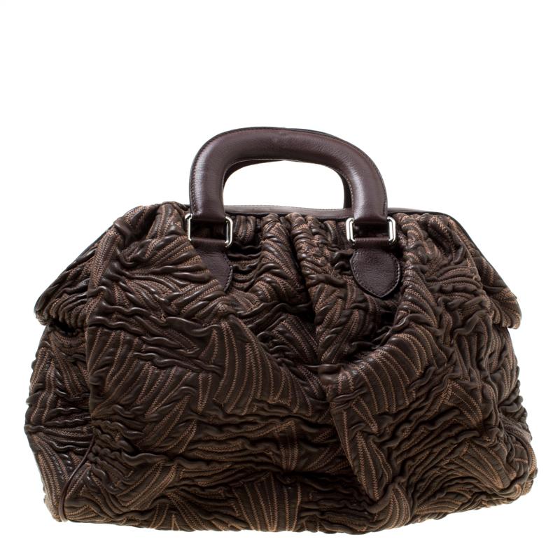 This Miss Curly bag by Dolce & Gabbana is a piece all fashionistas must look out for! Meticulously crafted from textured leather, it features a brown shade and leopard-printed kiss lock pockets. The bag is equipped with a spacious fabric interior