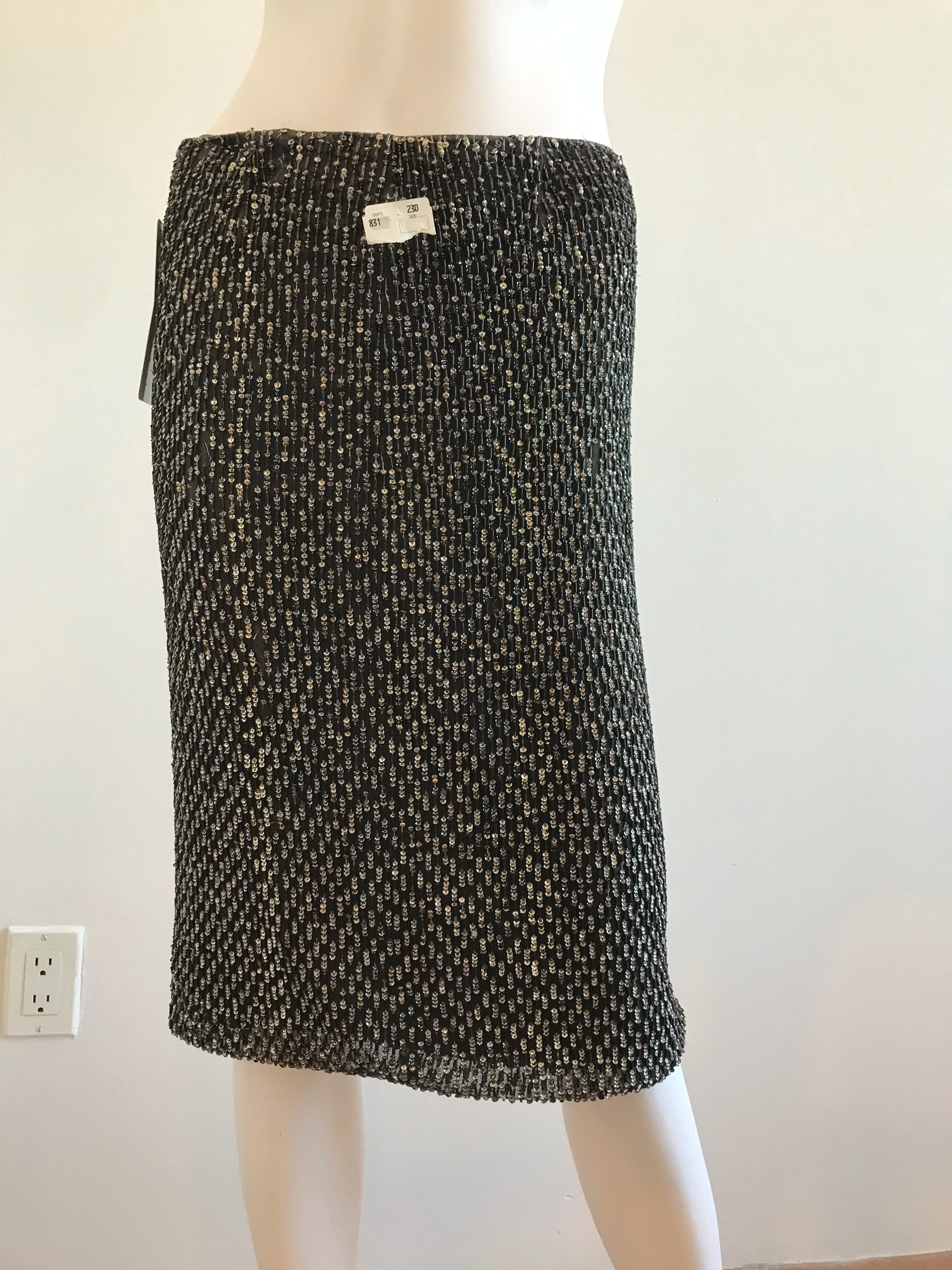 This Dolce & Gabbana slim skirt is completely beaded with black bugle beads, and accentuated with silver sequins. The elegant skirt is fully lined in black silk with an interior ribbon waistband and a back zipper enclosure. It is in good condition