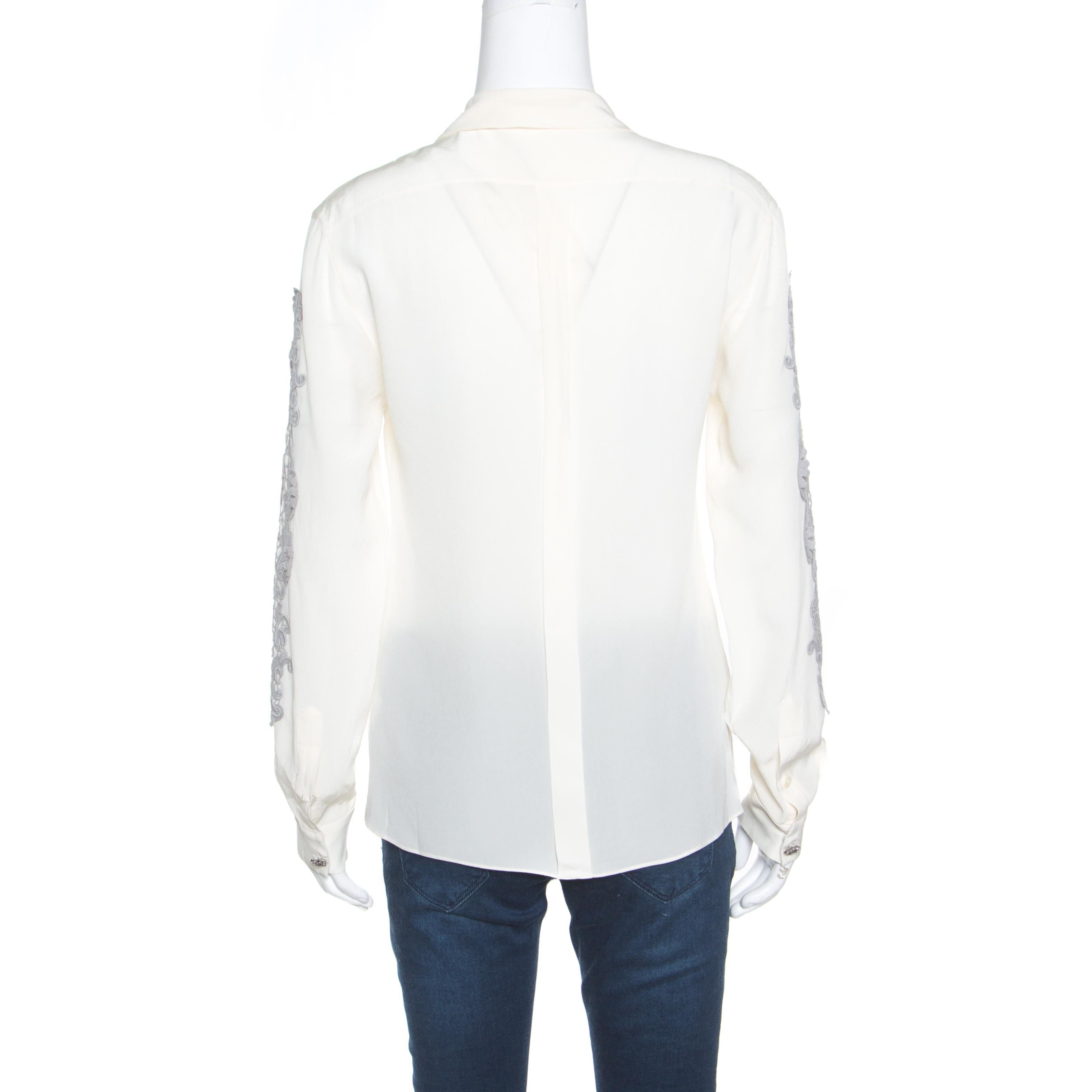 You'll find occasions to wear this lovely cream blouse from Dolce and Gabbana! It is made of a silk and crepe blend and features a bow tie detailing on the neckline. It flaunts long sleeves with an artistic lace applique design on the sides. Pair it