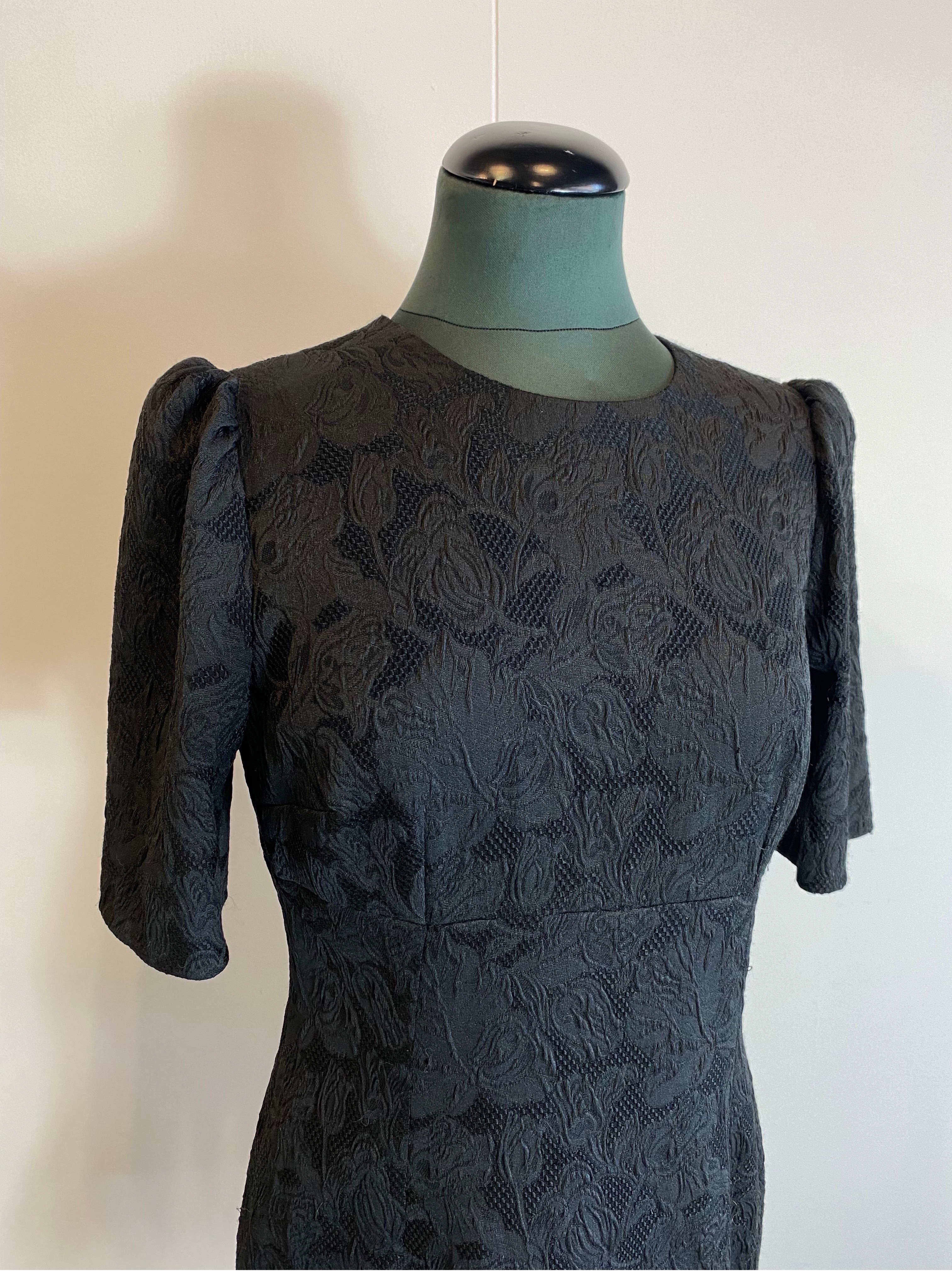 Dolce & Gabbana black dress with brocade flower motif 
In polyester, acetate and viscose. 
Silk and elastane lining. 
With flounce at the bottom, zip on the back.
Size 46.
Breast 46
Bust 43
Length 90
Sleeve length 31
In good overall condition, shows