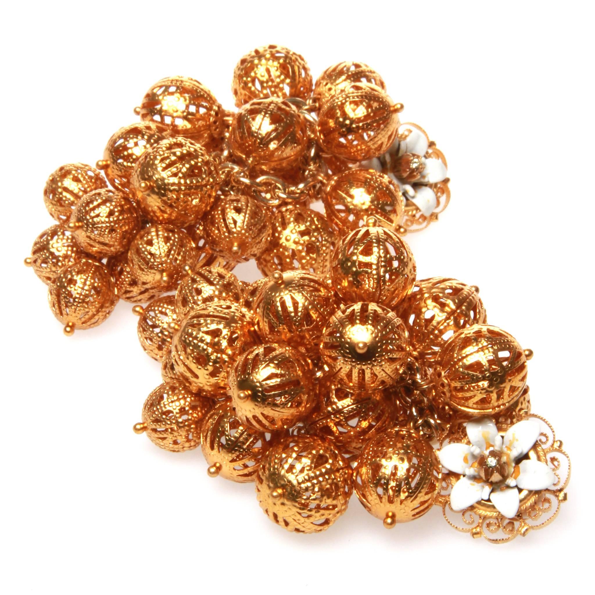 Dolce and Gabbana clip on earrings featuring a bunch of intricately metal-worked golden balls accented with small painted metal flowers.

Comes with original box. 
