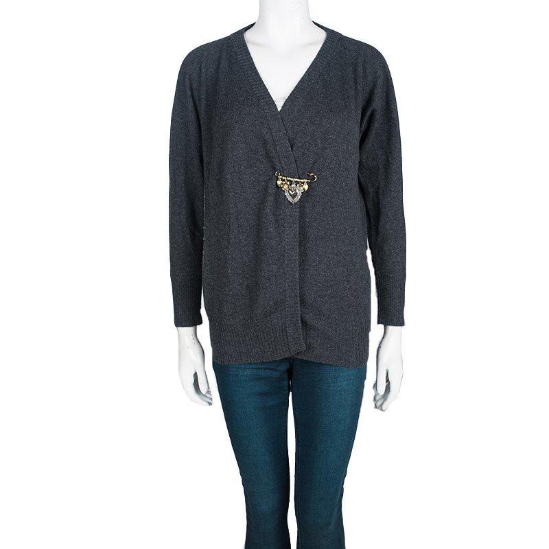 Luxuriously made from cashmere, this Dolce and Gabbana cardigan is a keeper. It carries a grey shade with long sleeves and a safety pin on the front that has little flower and heart charms. Simple yet high on style, this cardigan will be a great