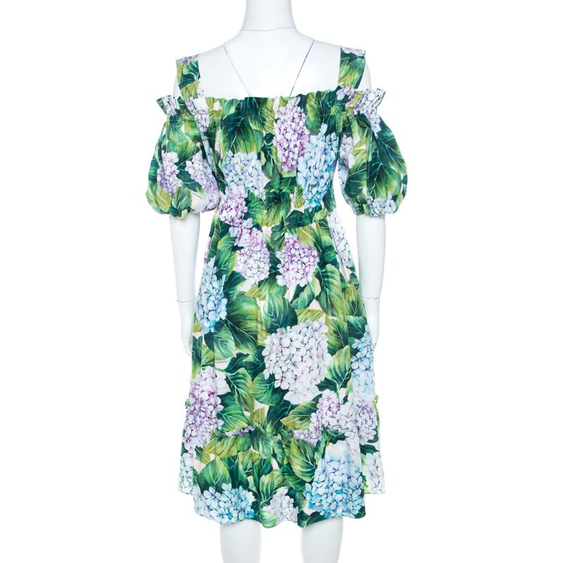 Amazingly stylish is this cold-shoulder dress from Dolce and Gabbana! It is made of 100% cotton and features a hydrangea print all over it. It flaunts an elasticised waistline and a short length. It'll look amazing with a pair of slingback sandals