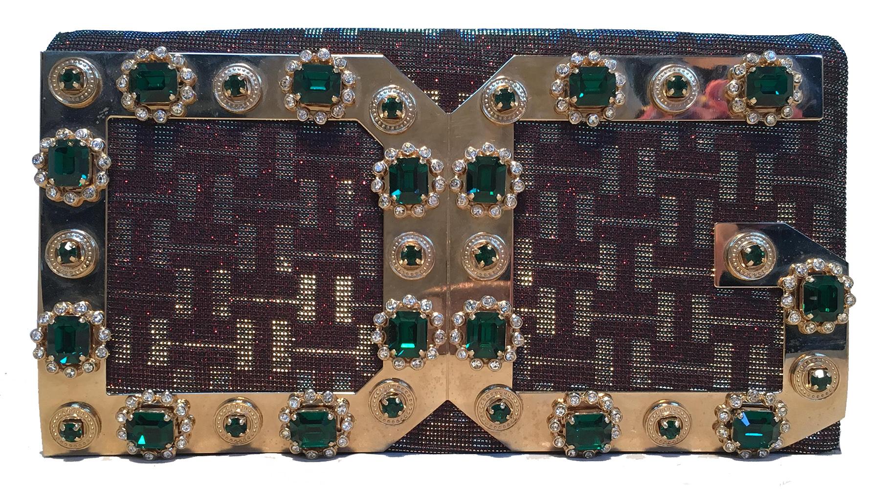 Dolce and Gabbana Iridescent DG Rhinestone Clutch in excellent condition. Iridescent woven nylon exterior trimmed with gold hardware and green rhinestones along front DG logo design. Snap flap closure opens to a black nylon interior that holds one
