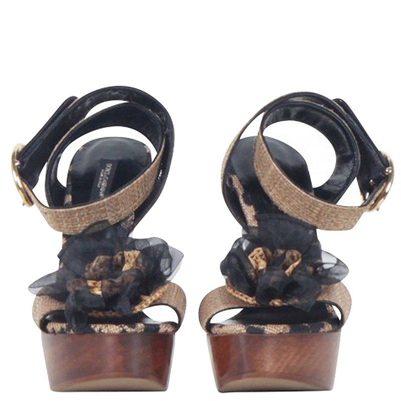 Dolce and Gabbana sandals are intricately woven at the frontal strap with a large flower motif and ankle strap closure. It comes with thick wooden heels and platforms. Styled in a brown hue makes this piece a versatile addition to your collection.