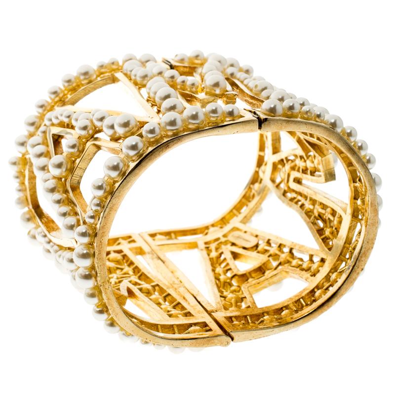 Show your love for luxury accessories with this stunning bracelet from Dolce&Gabbana. It has a gold-tone metal cuff design that is beautifully detailed with the letters MAMA and faux pearl embellishments, all laid in an artistic manner so as to