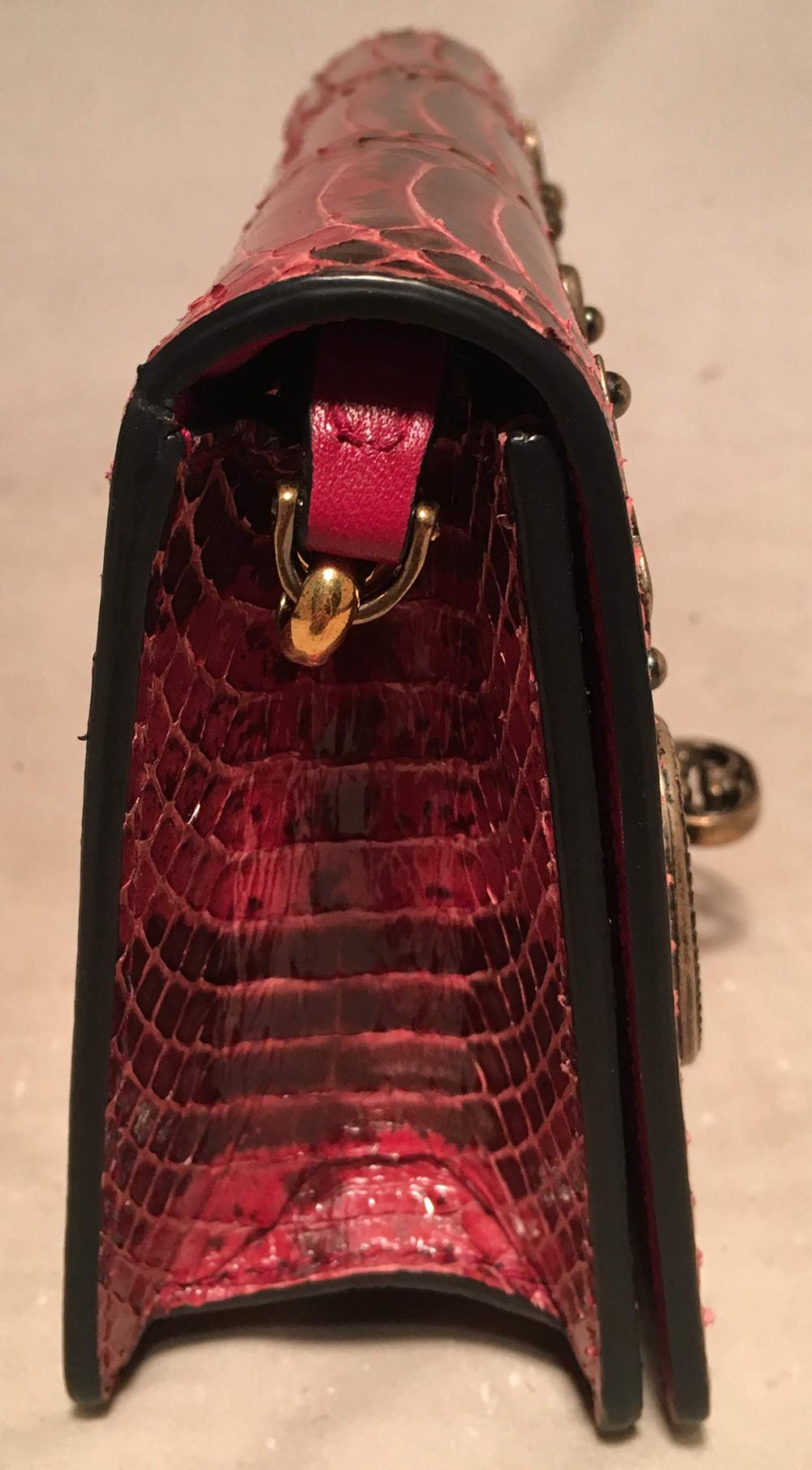 Dolce and Gabbana Maroon Snakeskin Keyhole Clutch Bag in like new condition. Maroon snakeskin exterior trimmed with antiqued bronze hardware and unique keyhole embellishments upon front flap. Black suede interior. Bronze chain handle converts from
