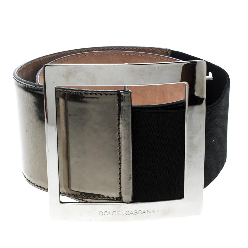 A classic add-on to your collection of belts, this Dolce and Gabbana belt has been crafted from the metallic grey patent in Italy. It has a polished finish and a square silver-tone buckle with an engraved brand name. This piece carries a classy