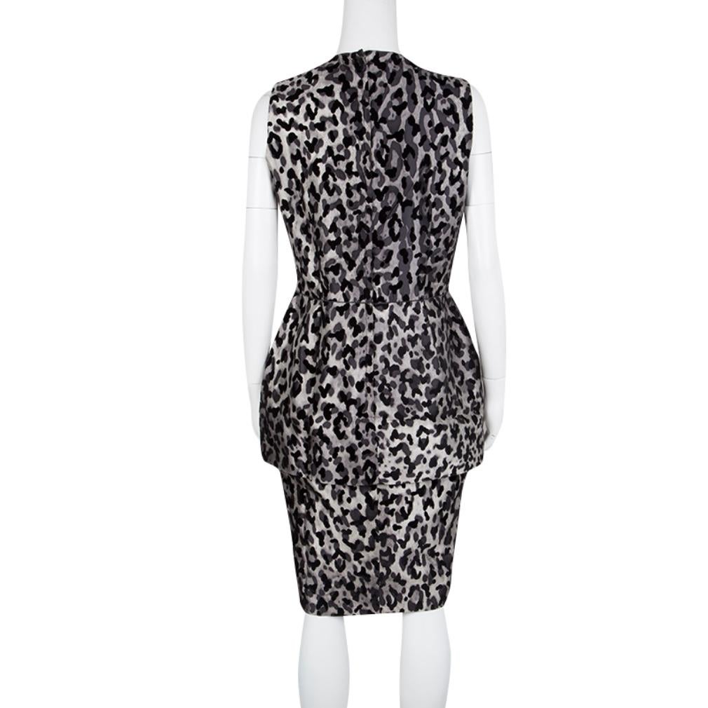 Constructed in grey monochrome flock animal printed silk blended fabric, this Dolce and Gabbana sleeveless dress is sure to make you stand out in the crowd. Featuring a layered peplum detail along the waist with a pencil skirt, this dress is