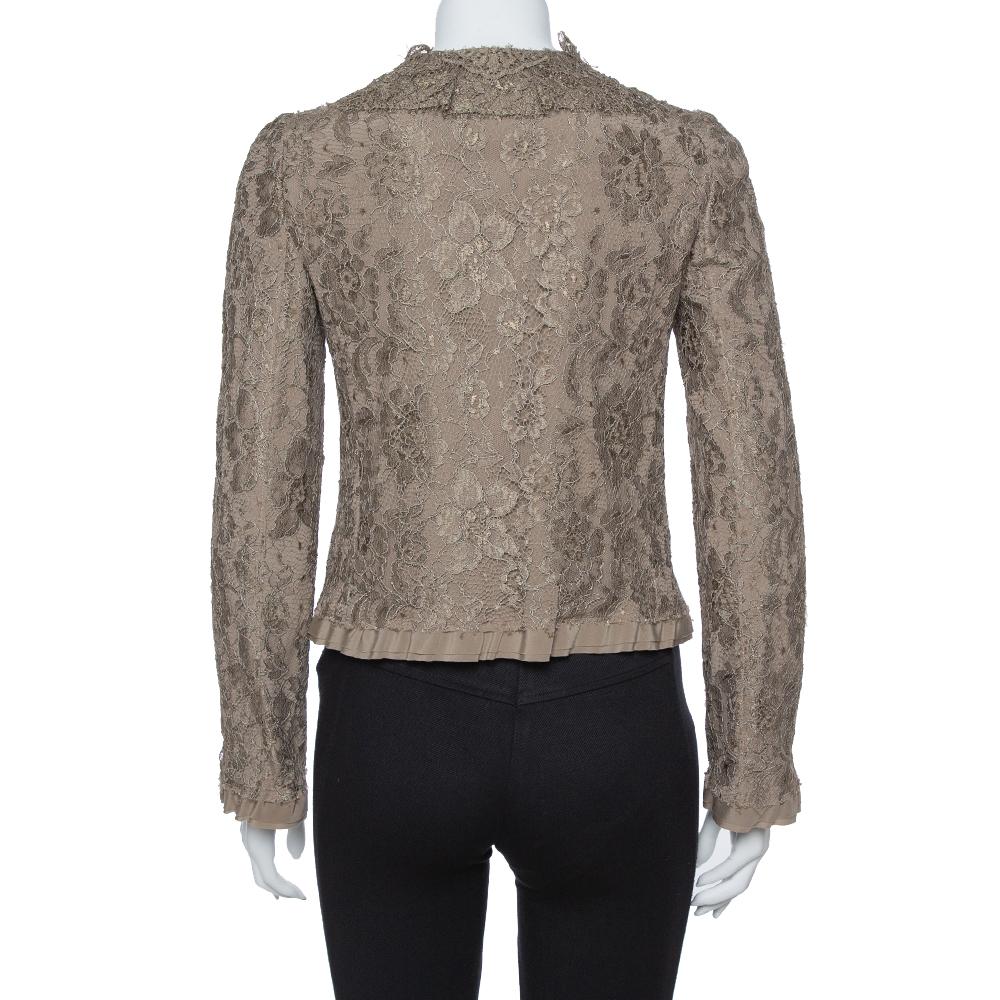 Dolce and Gabbana leave no occasion to charm us, and it yet again wins our hearts with this olive green jacket. It is made of a viscose blend and features a dainty floral lace textured design all over it. It flaunts a round neckline with a ruffle