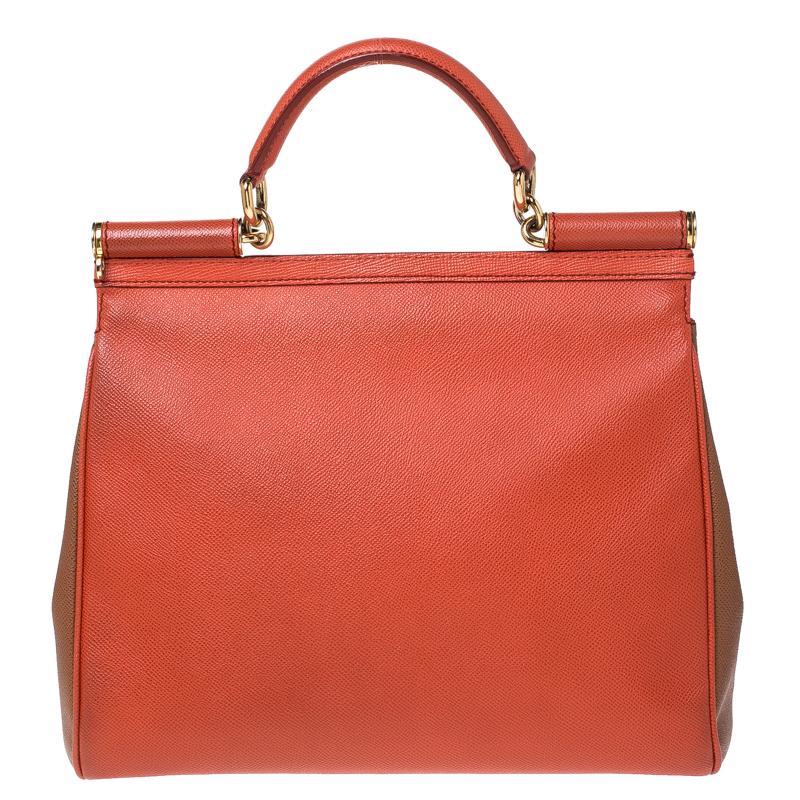 This gorgeous orange Miss Sicily satchel from Dolce & Gabbana is a handbag coveted by women around the world. It has a well-structured design and a flap that opens to a compartment with fabric lining and enough space to fit your essentials. The bag