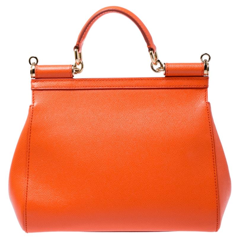 This gorgeous orange Miss Sicily satchel from Dolce & Gabbana is a handbag coveted by women around the world. It has a well-structured design and a flap that opens to a compartment with fabric lining and enough space to fit your essentials. The bag