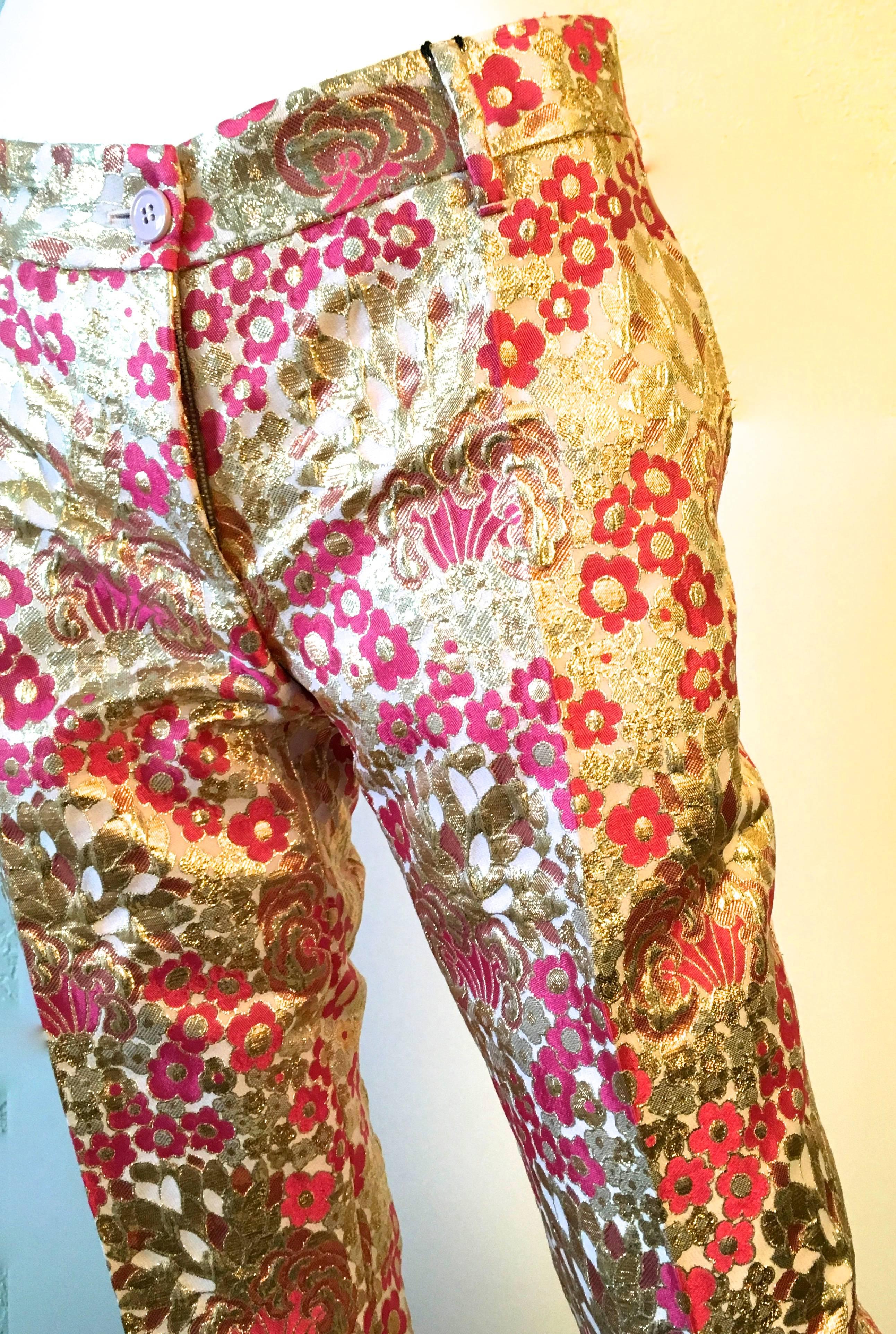 Presented here is a magnificent pair of Dolce and Gabbana pants. The pants are a size 36. The silk brocade fabric is absolutely magnificent and the fabric is woven threads of gold and light pink and magenta flowers throughout. These pants are in