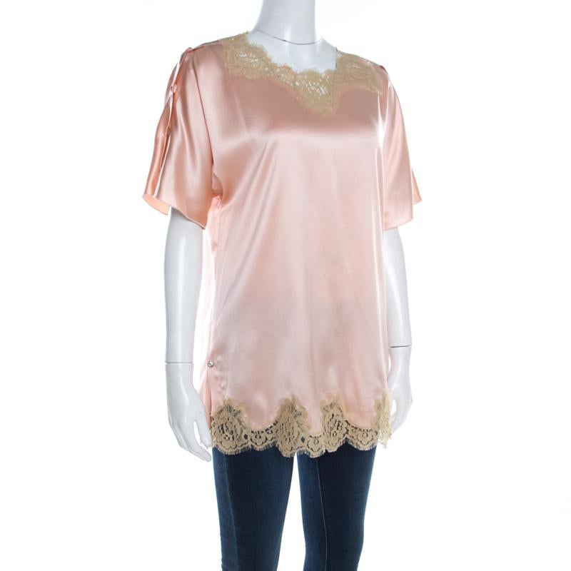 This Dolce & Gabbana blouse exhibits mastery in crafting classic silhouettes and lending a free-flowing look. This peach piece, skillfully tailored from satin silk, features lace trims and kimono sleeves.

Includes: The Luxury Closet Packaging, Info