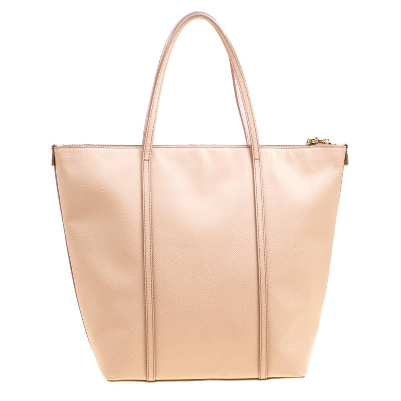 Add a touch of class to your look with this Dolce & Gabbana tote. Part of the Miss Escape collection, this bag is crafted from leather flaunting a pink hue at the front and a beige hue at the rear along with a gold-tone logo plaque and a leather tag