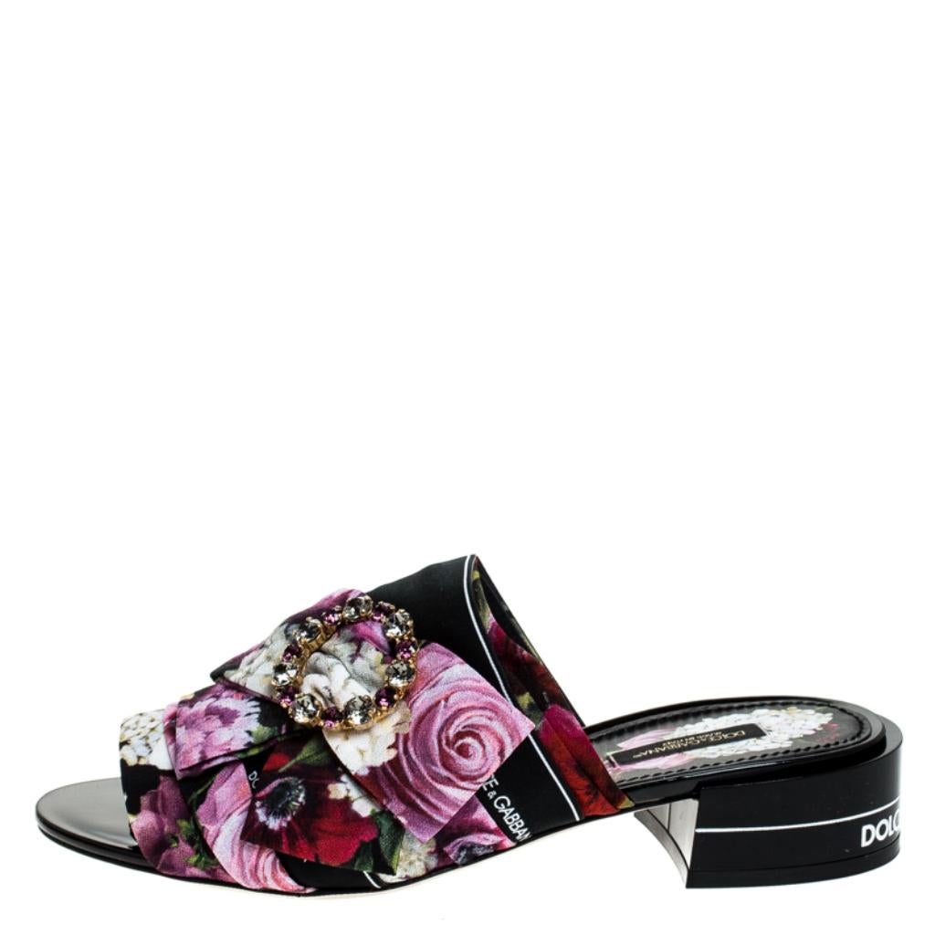 Elegant with a lush floral-printed fabric exterior, these easy slip-on mules from Dolce & Gabbana are pretty and feminine. They are designed with open toes, embellished buckles with bows and short heels carrying the brand name.

Includes: Original