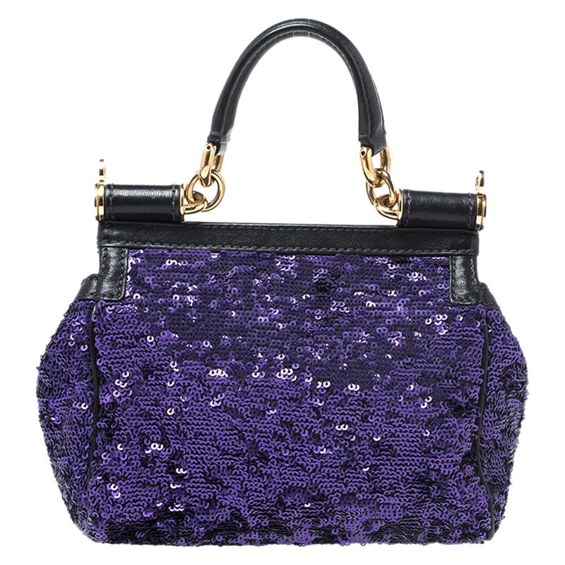 This gorgeous purple & black Miss Sicily satchel from Dolce & Gabbana is a handbag coveted by women around the world. It has been crafted from sequins and leather. It has a well-structured design and a flap that opens to a compartment with fabric