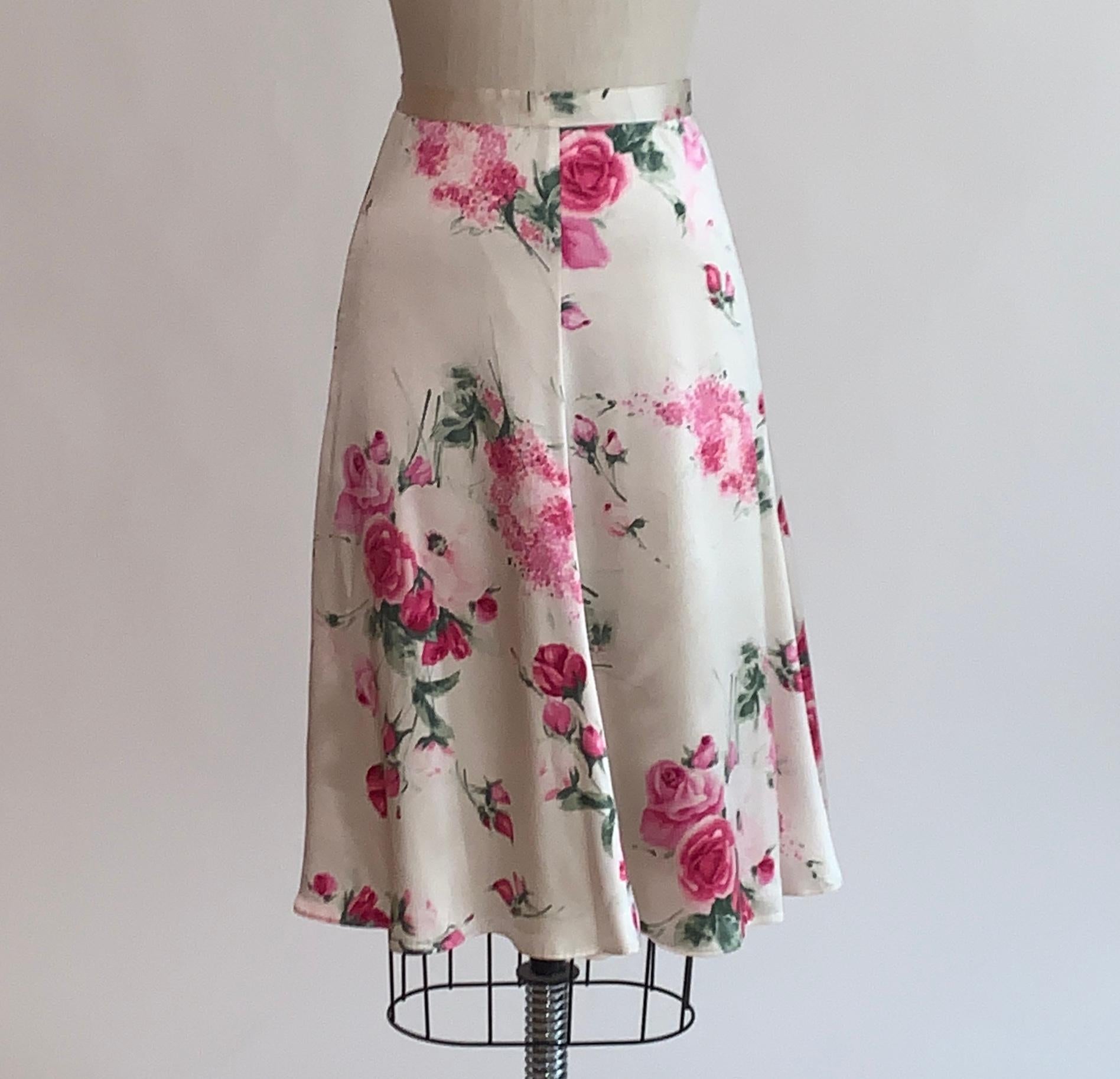 Dolce and Gabbana floral print skirt in a pink and green rose and floral (pink lilac?) pattern on a creamy white background. Back zip and snaps. Branded DG at back zipper pull.

95% silk, 5% spandex.
Fully lined in 78% acetate, 6% spandex, 16%