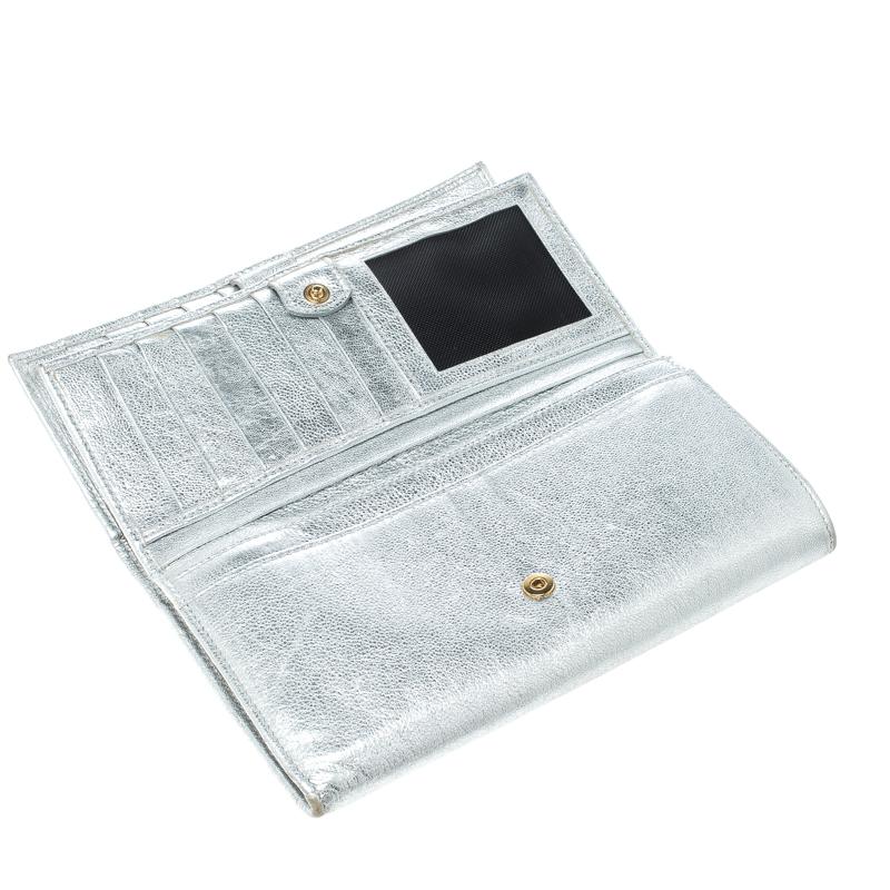 This stunning wallet from Dolce and Gabbana can be transformed into an evening clutch, as its beautiful metallic silver leather is perfect to glam you up with minimal effort. Featuring a gold tone brand name engraved plate at the front, this wallet