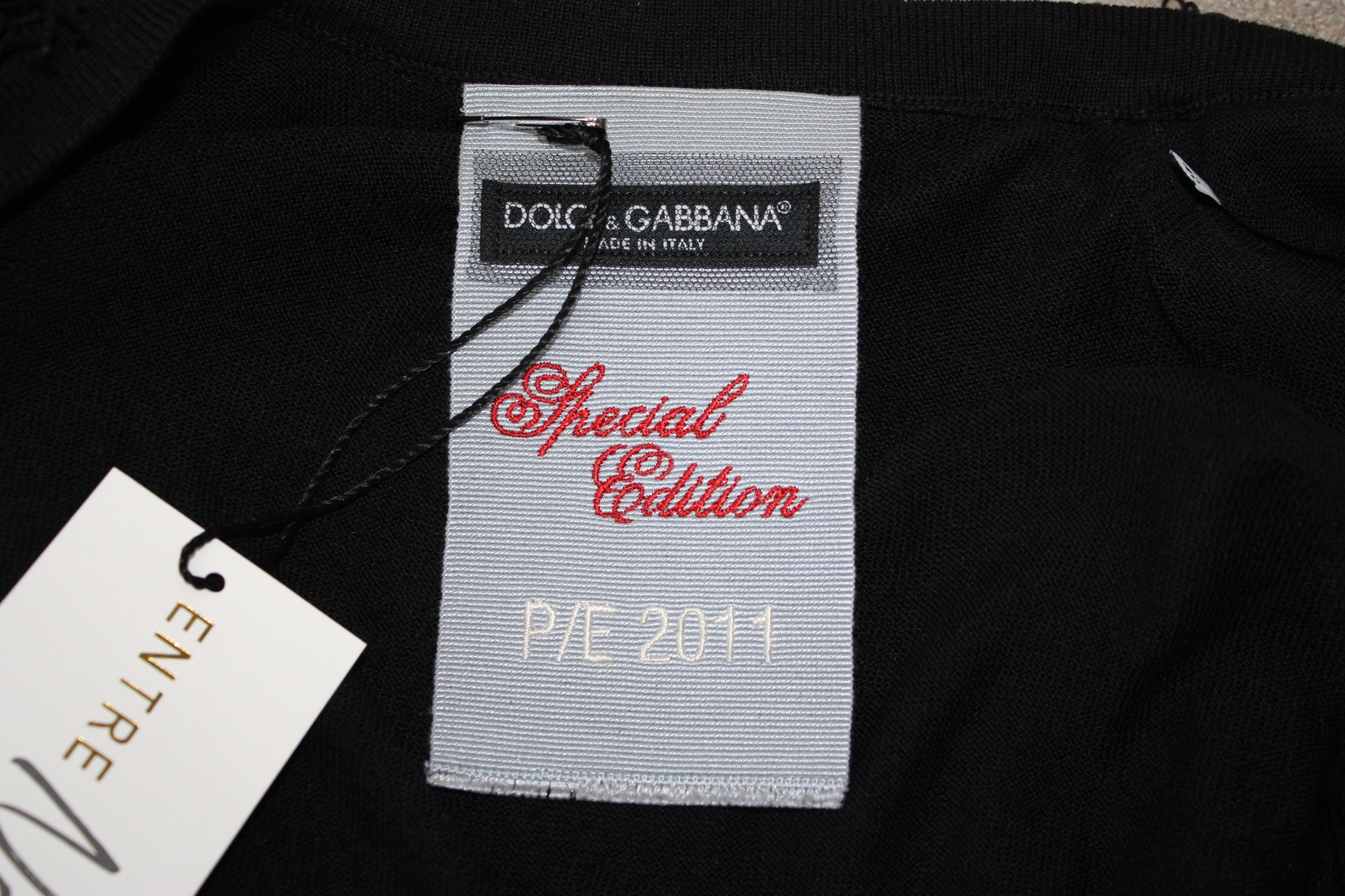 Cardigan à franges noir édition spéciale Dolce and Gabbana. manches 3/4. Boutons noirs ton sur ton avec Dolce et Gabbana gravés dessus. Taille XS. 