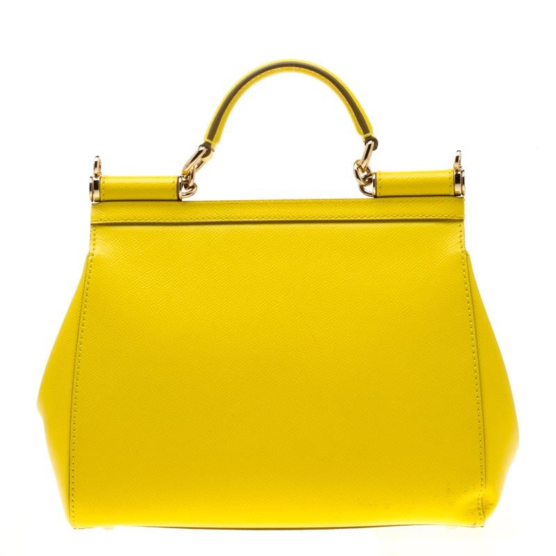 This gorgeous yellow Miss Sicily satchel from Dolce & Gabbana is a handbag coveted by women around the world. It has a well-structured design and a flap that opens to a compartment with fabric lining and enough space to fit your essentials. The bag